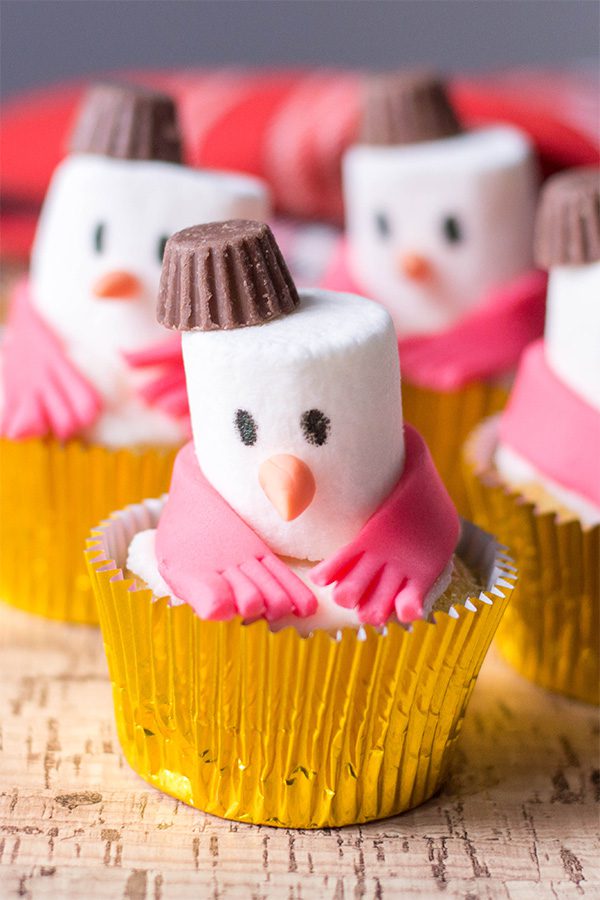24 Easy & Creative Christmas Cupcakes to Try Right Now 63 24 Easy & Creative Christmas Cupcakes to Try Right Now Cute snowman cupcakes with marshmallow heads, chocolate hats, and pink fondant scarves