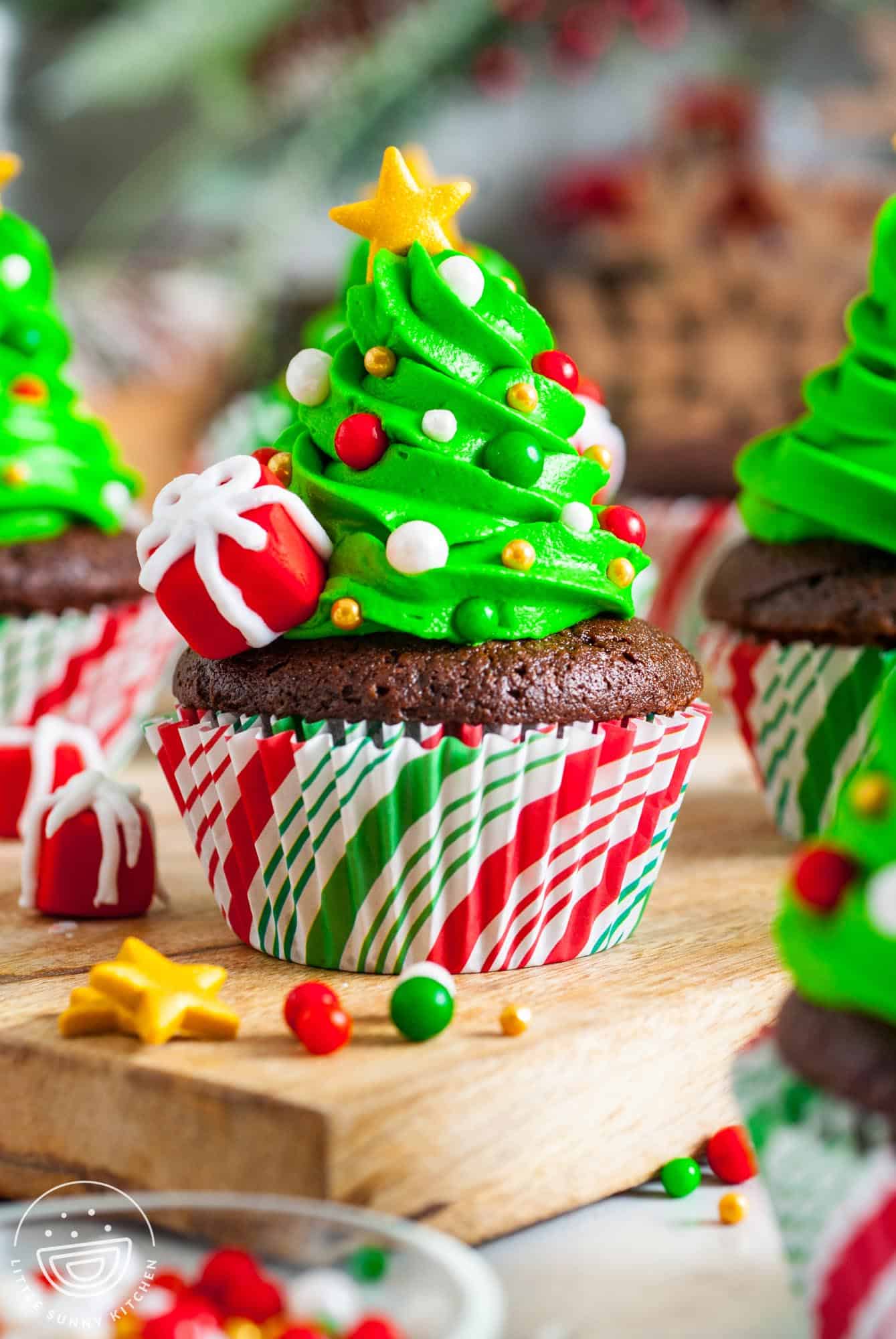 24 Easy & Creative Christmas Cupcakes to Try Right Now 49 24 Easy & Creative Christmas Cupcakes to Try Right Now Christmas tree cupcakes with green frosting, colorful decorations, and yellow stars
