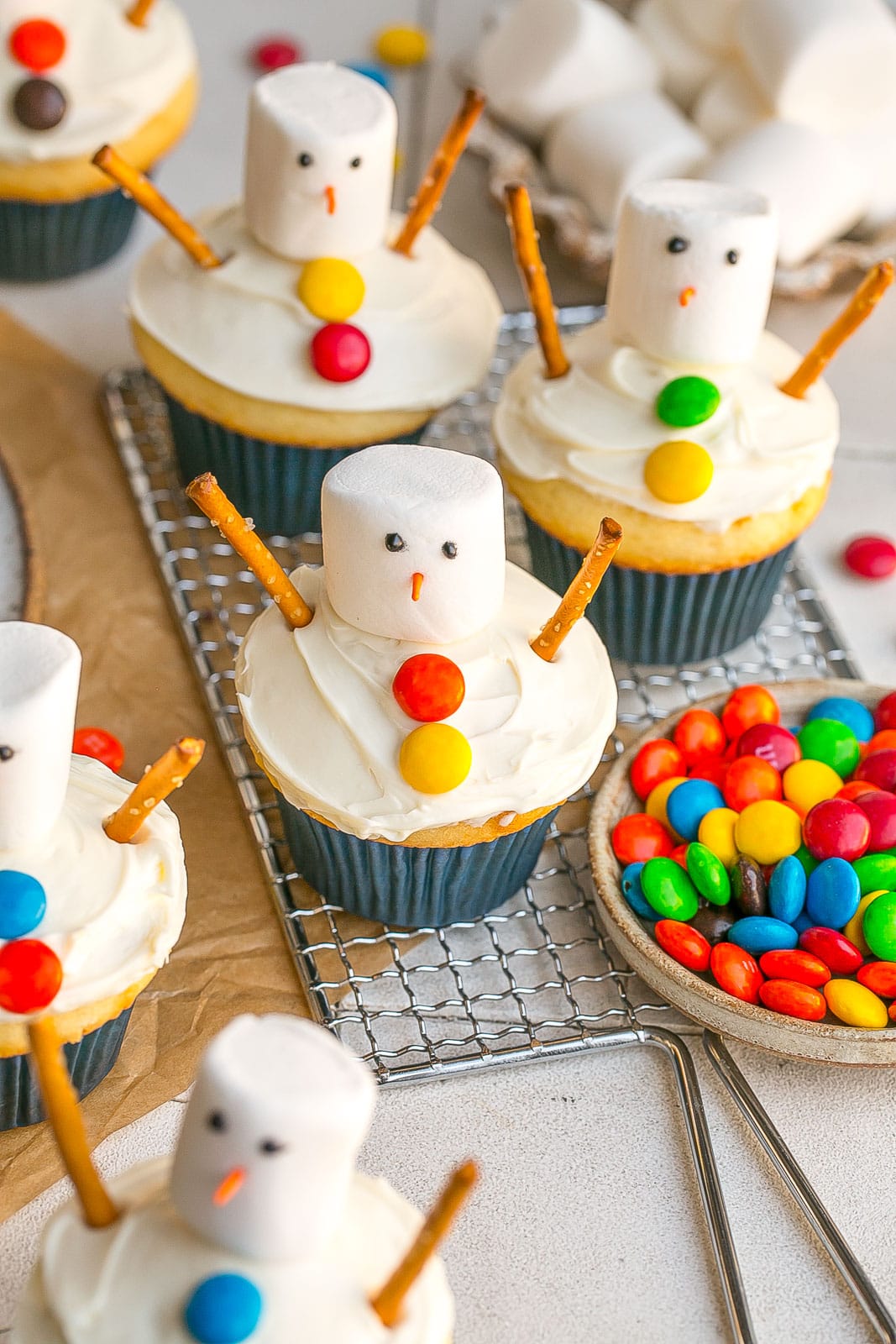 24 Easy & Creative Christmas Cupcakes to Try Right Now 52 24 Easy & Creative Christmas Cupcakes to Try Right Now Snowman cupcakes with marshmallow heads, chocolate hats, and pink scarves