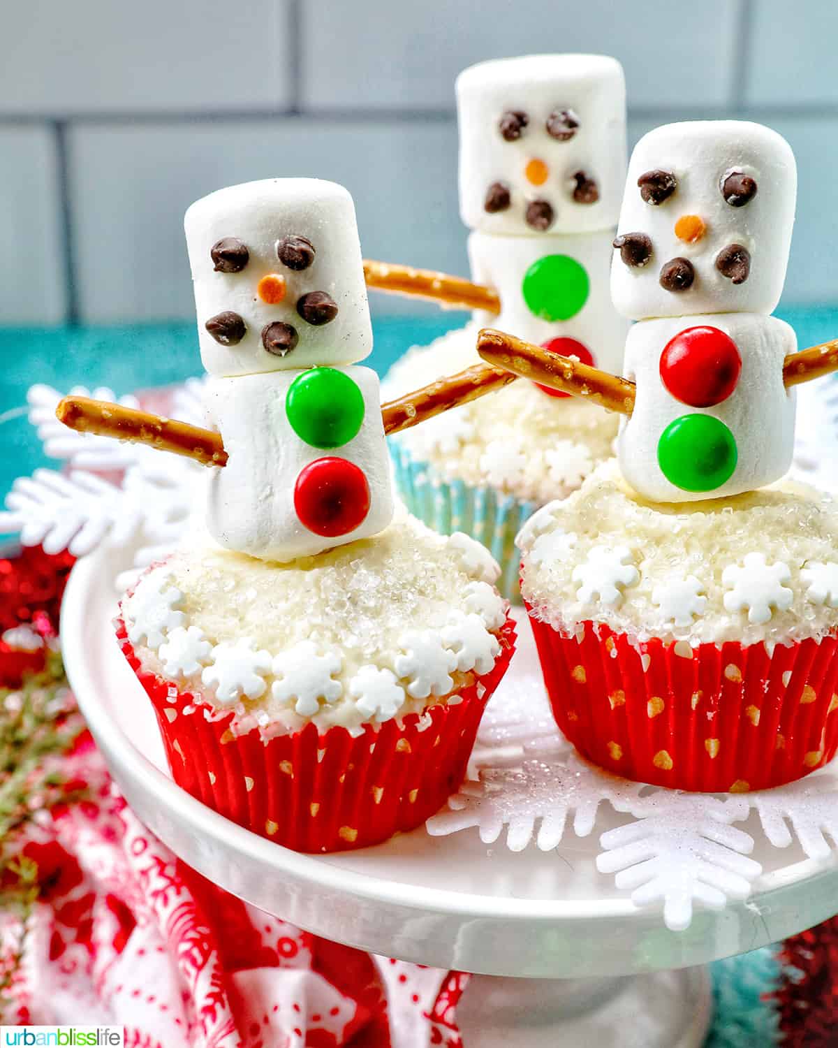 24 Easy & Creative Christmas Cupcakes to Try Right Now 59 24 Easy & Creative Christmas Cupcakes to Try Right Now Snowman cupcakes decorated with white frosting, colorful M&Ms, and black icing light strings