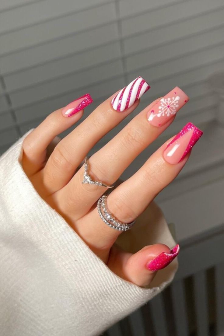 Pink Christmas coffin nails with glitter French tips, white candy cane stripes, and a snowflake accent