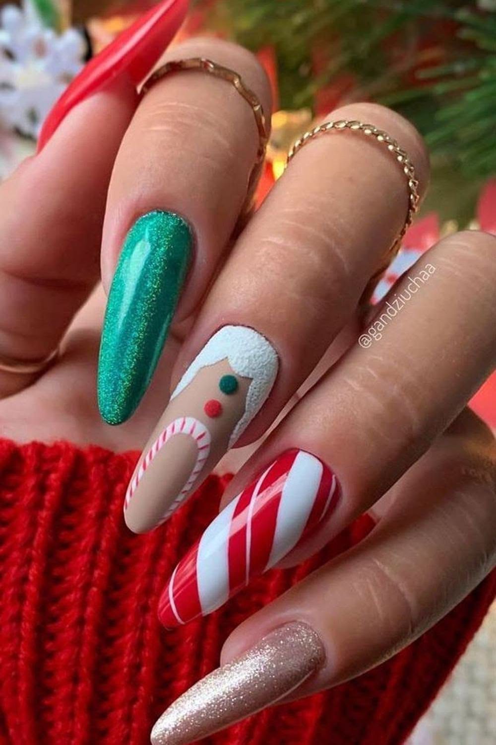 Long Christmas nails with a reindeer face, green shimmer polish, candy cane stripes, and silver glitter