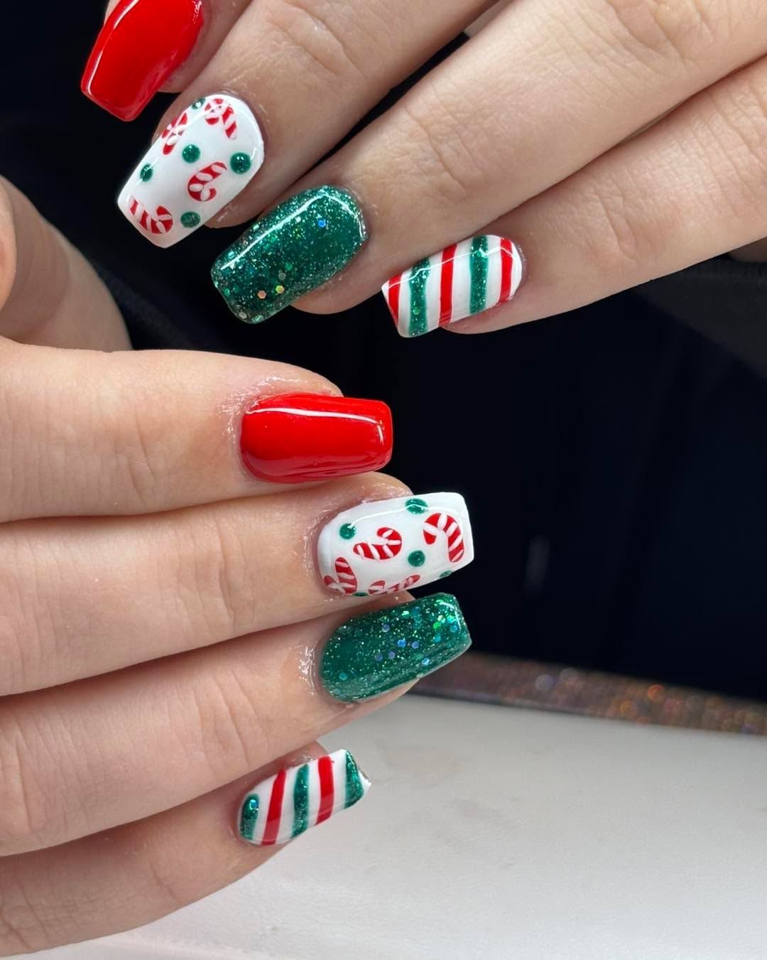 Mint green Christmas nails with tiny candy canes, glossy red accents, and red and white stripes