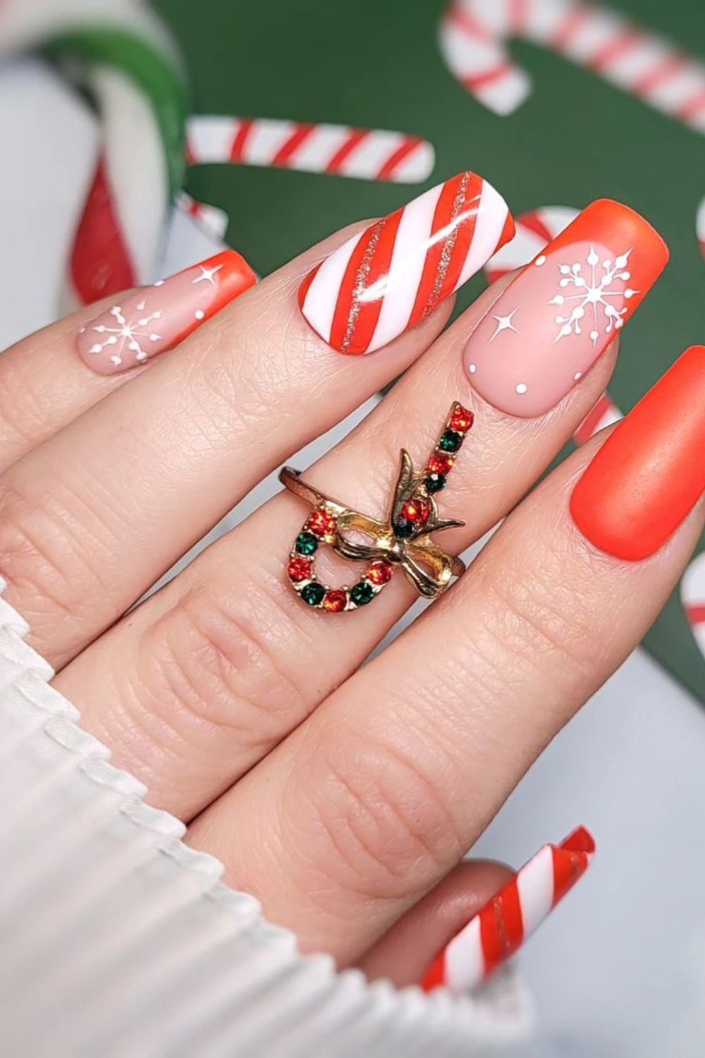 Square Christmas nails with emerald green glitter, tiny candy canes on white, and red and green striped accents