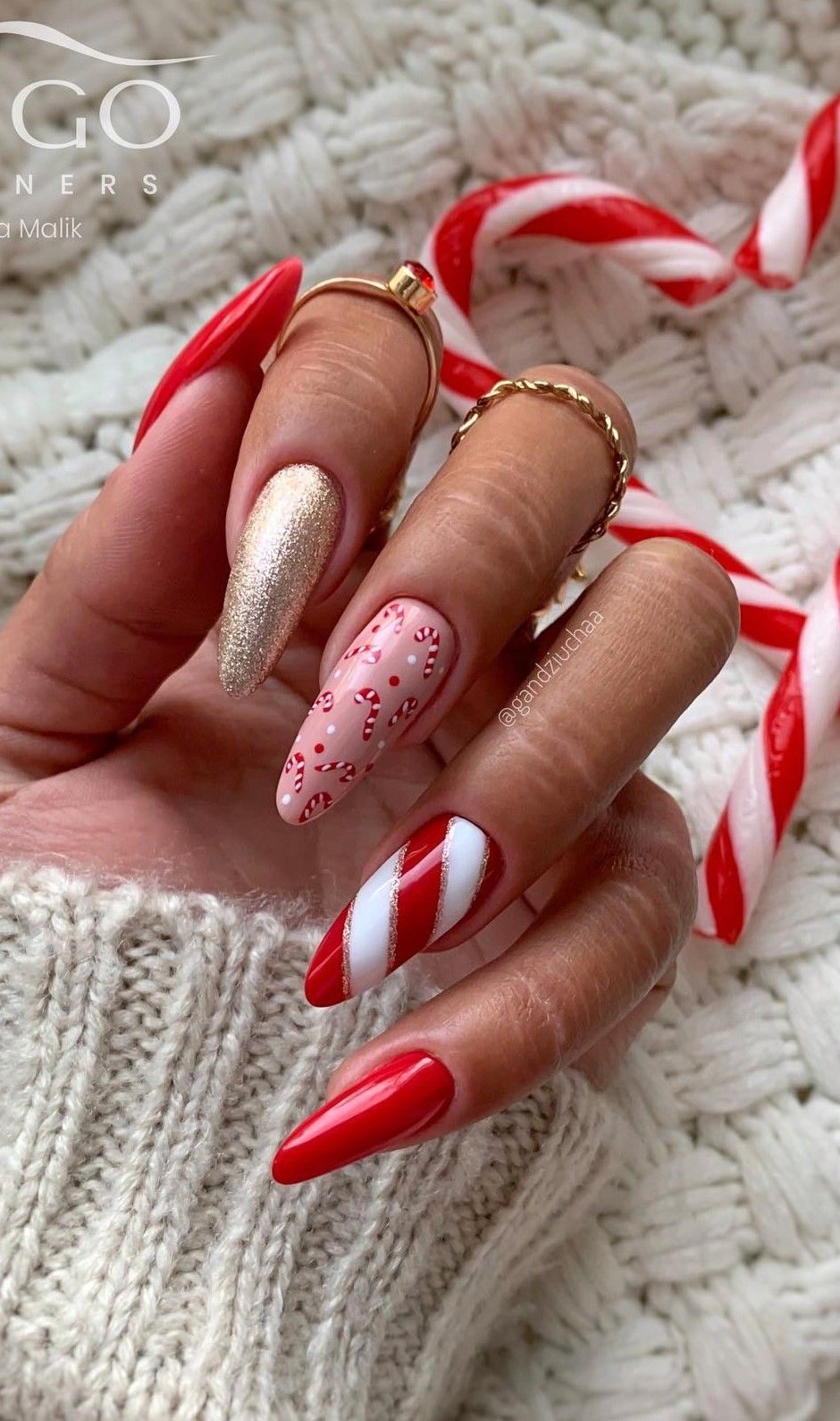Pink and red Christmas almond nails with candy cane stripes, ribbon bows, snowflakes, and French tips