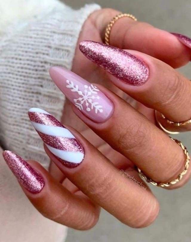 Red Christmas almond nails with champagne gold glitter, miniature candy canes, and red and white striped accents