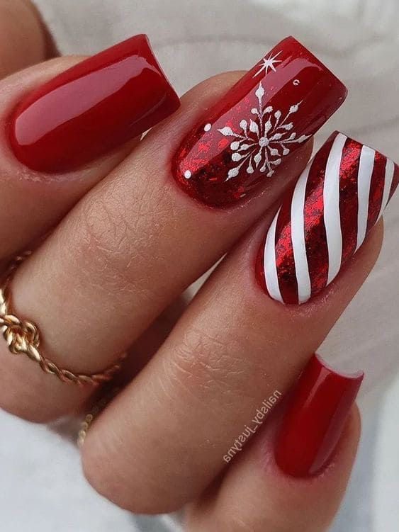 Short coffin Christmas nails in deep red with white snowflake art and metallic red candy cane stripes