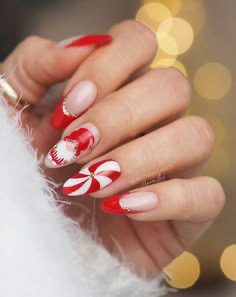 Red and white Christmas nails with peppermint swirl art, candy cane accents, and glittery French tips