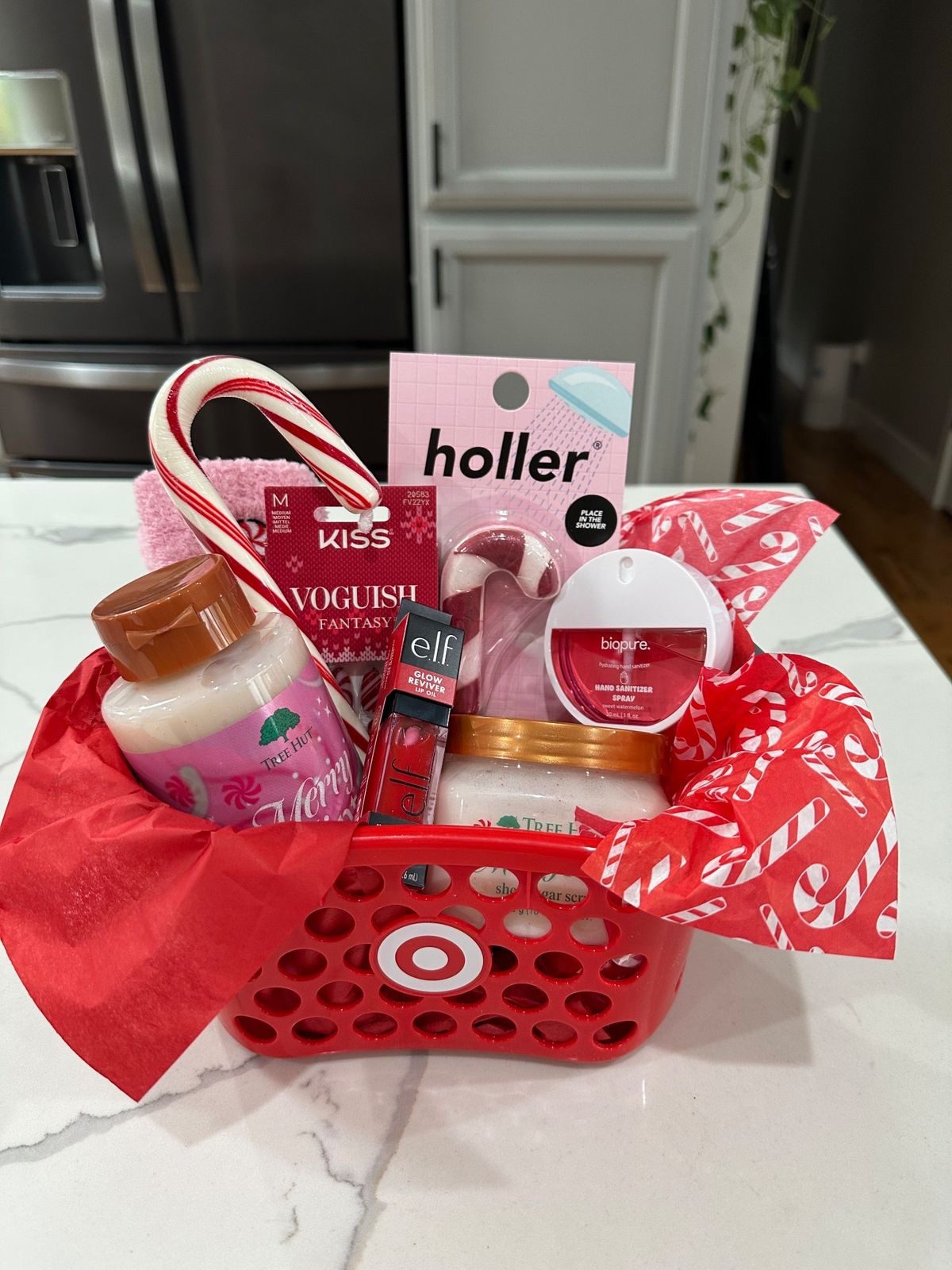 30 Thoughtful Christmas Gift Basket Ideas for Her 70 30 Thoughtful Christmas Gift Basket Ideas for Her Mini red shopping basket with Tree Hut products, lip oil, nail gifts and candy-cane tissue paper