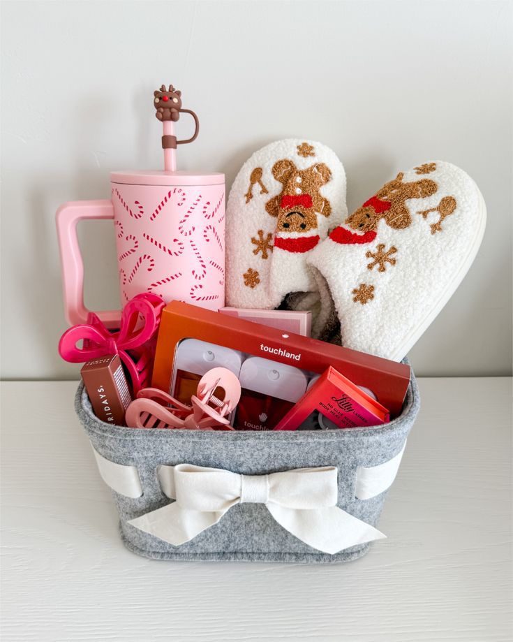 30 Thoughtful Christmas Gift Basket Ideas for Her 75 30 Thoughtful Christmas Gift Basket Ideas for Her Grey gift basket with a pink handled tumbler, reindeer slippers and pink beauty accessories