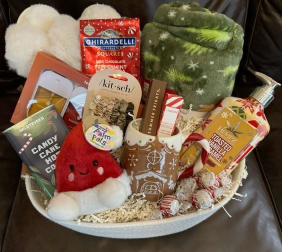 30 Thoughtful Christmas Gift Basket Ideas for Her 79 30 Thoughtful Christmas Gift Basket Ideas for Her Winter gift basket with a green patterned blanket, chocolates, beauty accessories and festive treats