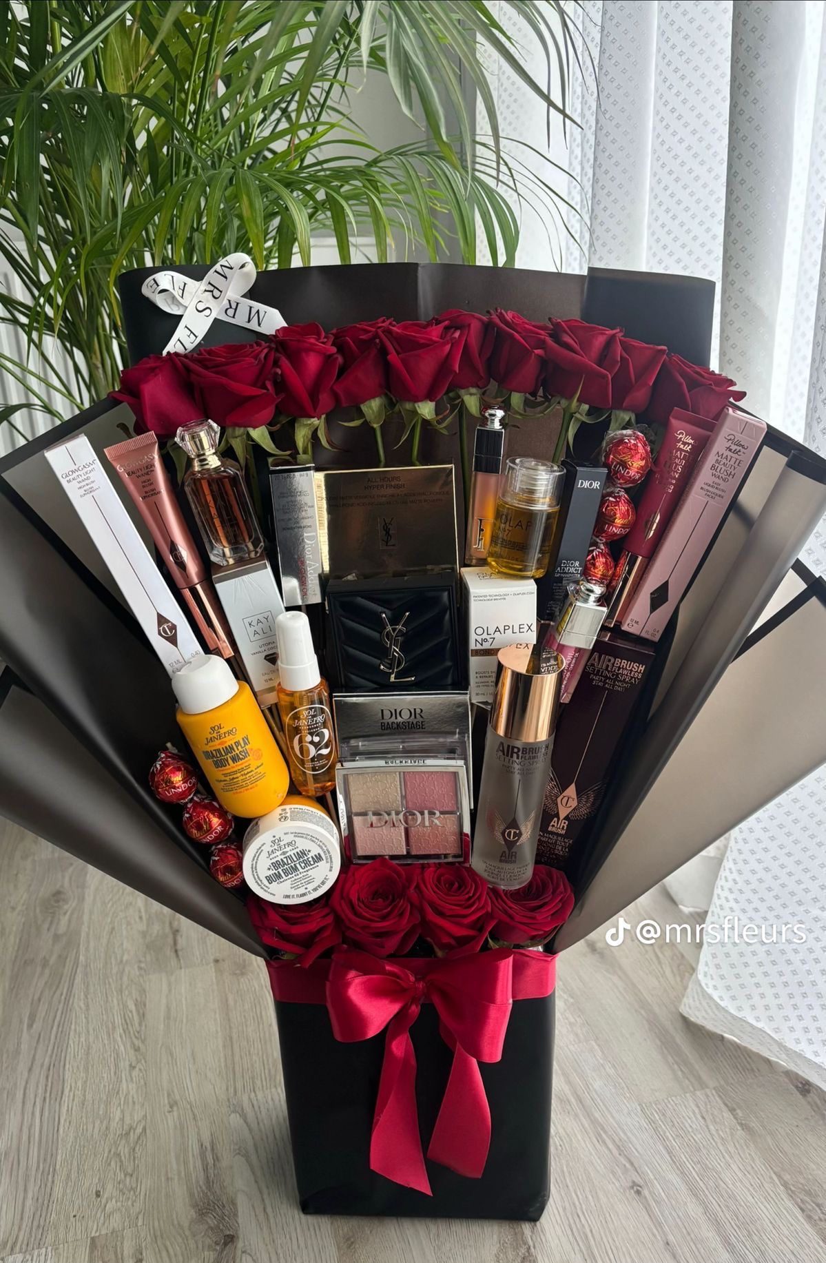 30 Thoughtful Christmas Gift Basket Ideas for Her 86 30 Thoughtful Christmas Gift Basket Ideas for Her Luxury gift bouquet with red roses, beauty products, fragrance and black wrapping tied with red ribbon