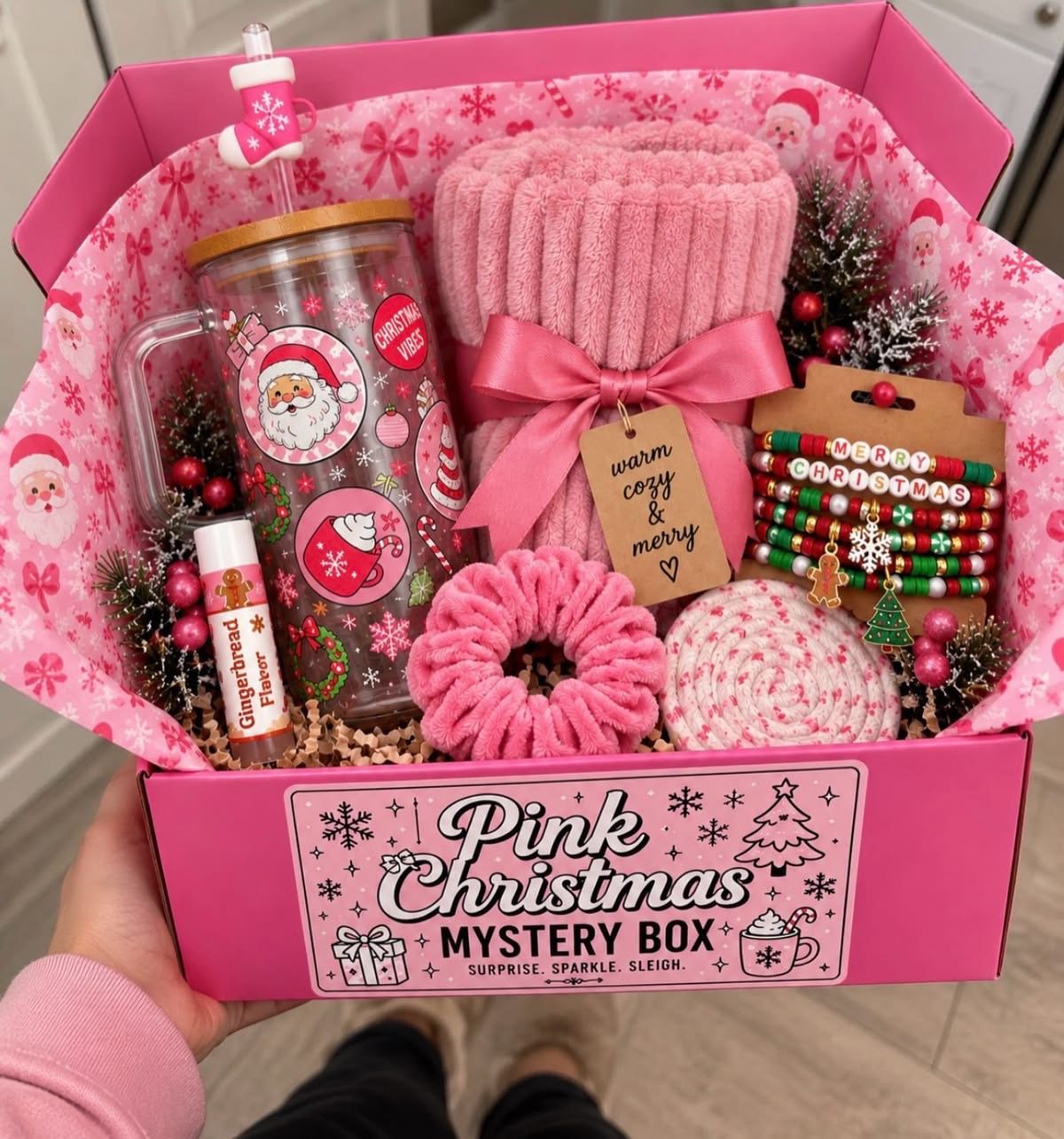 30 Thoughtful Christmas Gift Basket Ideas for Her 63 30 Thoughtful Christmas Gift Basket Ideas for Her Pink Christmas gift box with a festive tumbler, rolled blanket, scrunchie, lip balm and bracelets