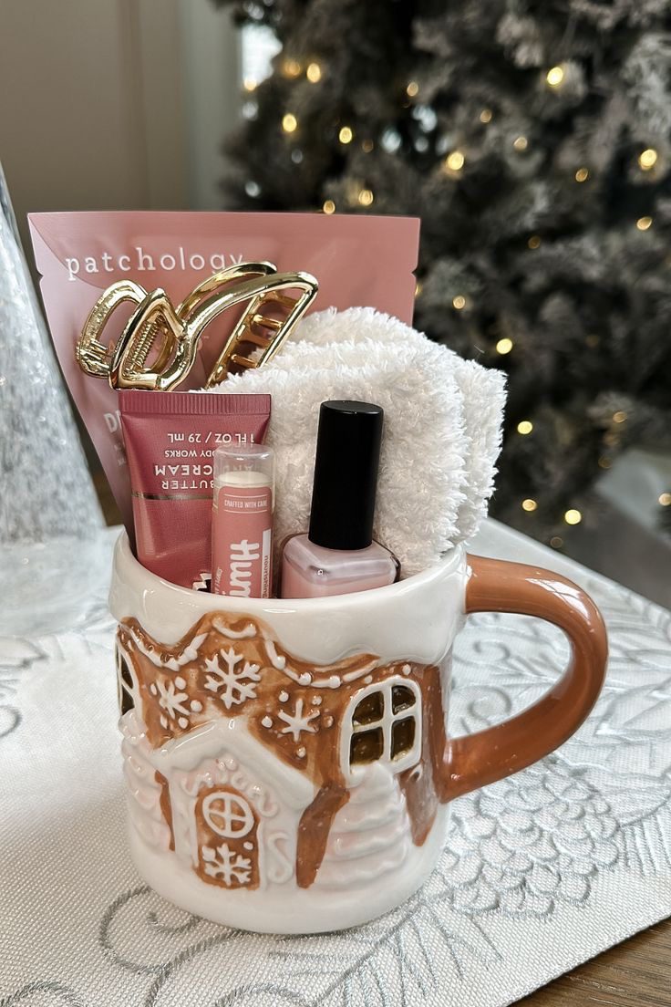 30 Thoughtful Christmas Gift Basket Ideas for Her 64 30 Thoughtful Christmas Gift Basket Ideas for Her Gingerbread house mug filled with beauty treats, a gold hair clip and fluffy white socks