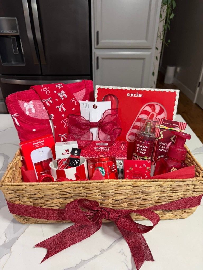 30 Thoughtful Christmas Gift Basket Ideas for Her 66 30 Thoughtful Christmas Gift Basket Ideas for Her Wicker Christmas gift basket filled with red beauty gifts, festive treats and a candy cane