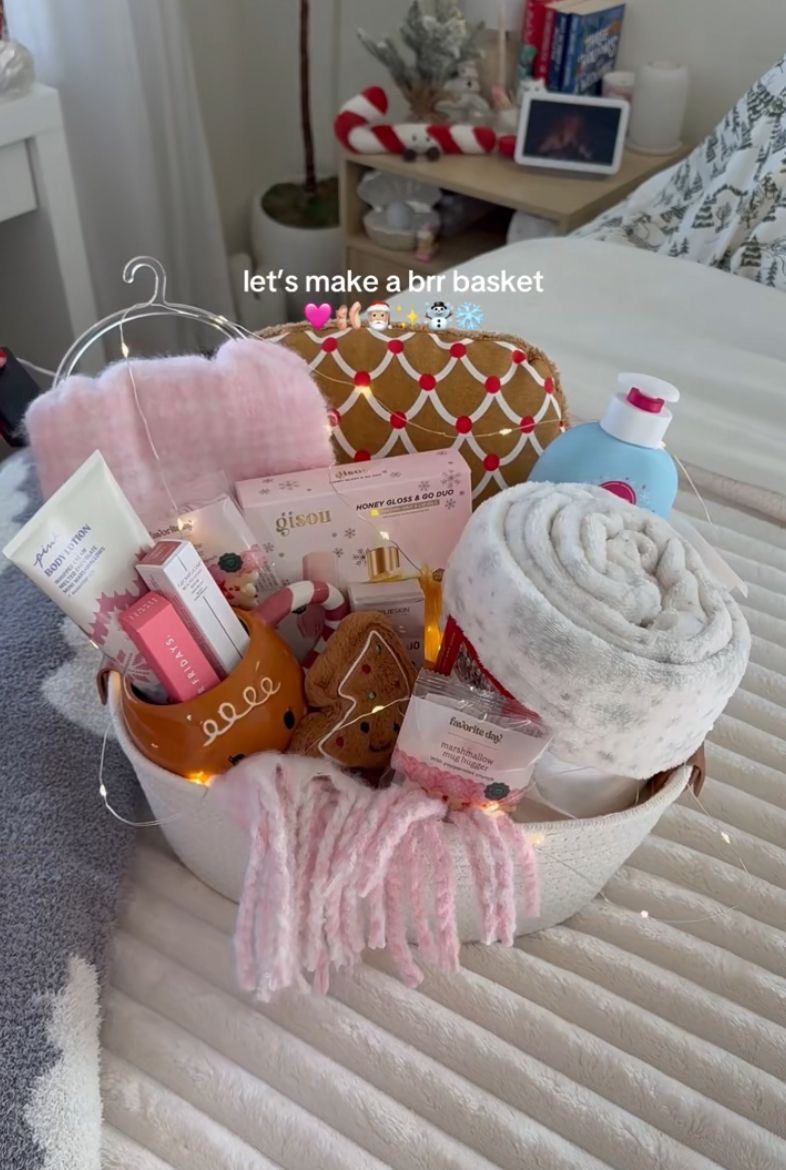 30 Thoughtful Christmas Gift Basket Ideas for Her 68 30 Thoughtful Christmas Gift Basket Ideas for Her Cosy Christmas basket with a rolled grey blanket, pink accessories, beauty gifts and a gingerbread mug