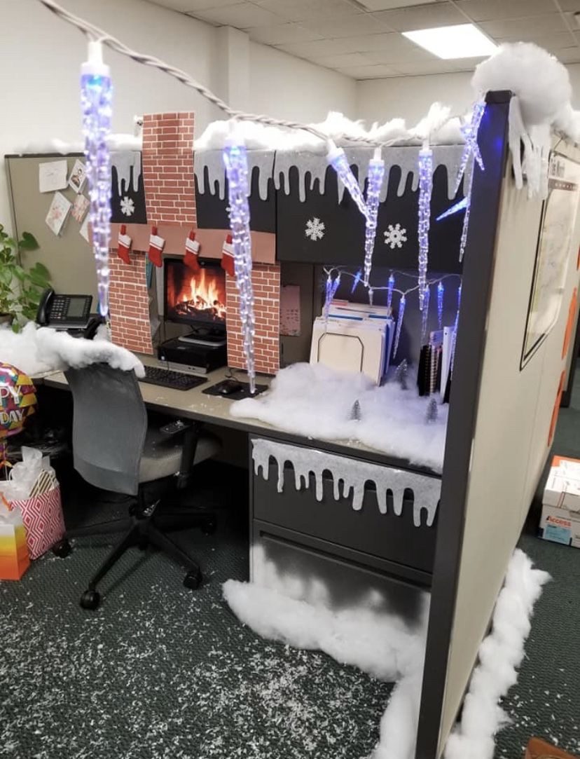 Christmas office cubicle transformed into a snowy fireplace scene with hanging icicle lights