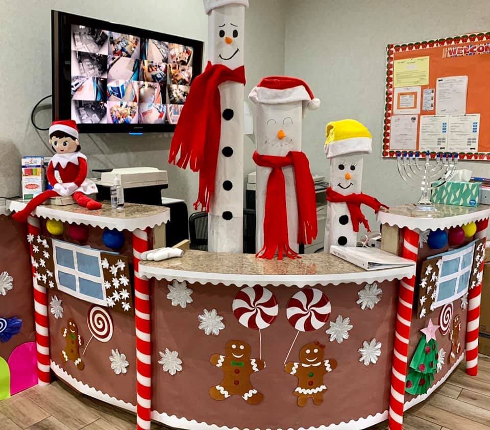 Christmas reception desk decorated like a gingerbread house with snowman columns and candy decorations