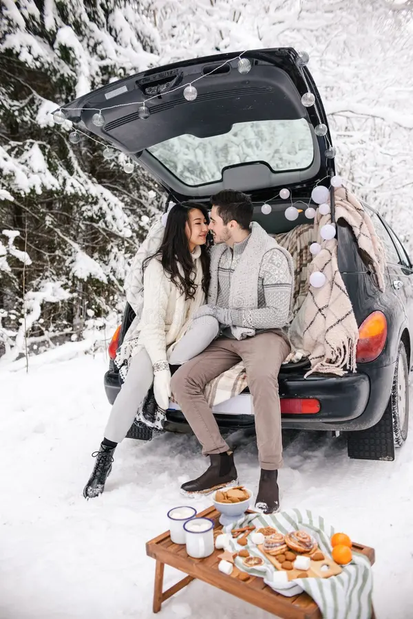30 Cozy & Fun Winter Date Ideas for Couples 61 30 Cozy & Fun Winter Date Ideas for Couples Couple enjoying a snowy winter picnic beside an open car boot