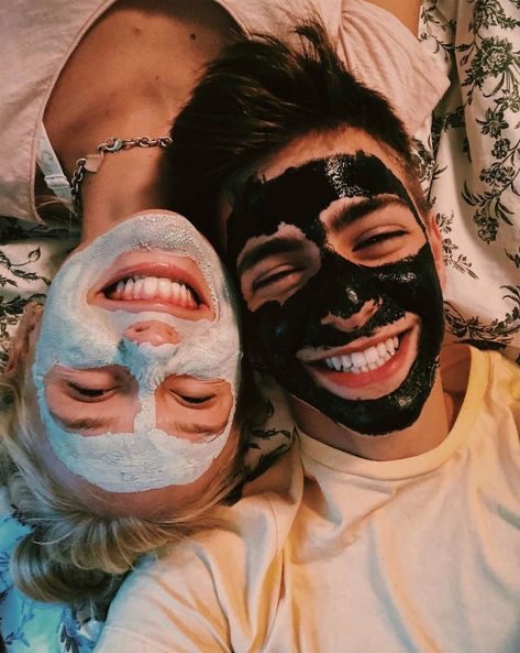 Couple relaxing together while wearing skincare face masks