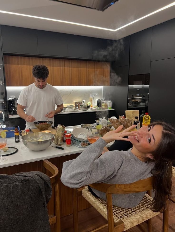 Couple preparing dinner together in a kitchen with ingredients spread across the counter