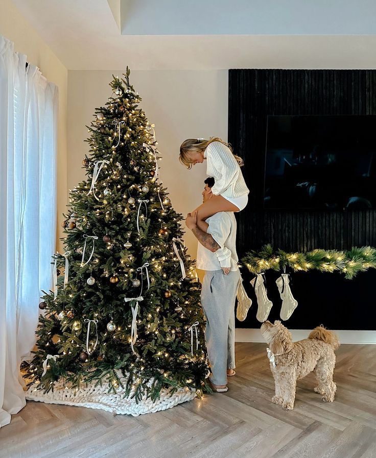 Couple decorating a Christmas tree together in their living room