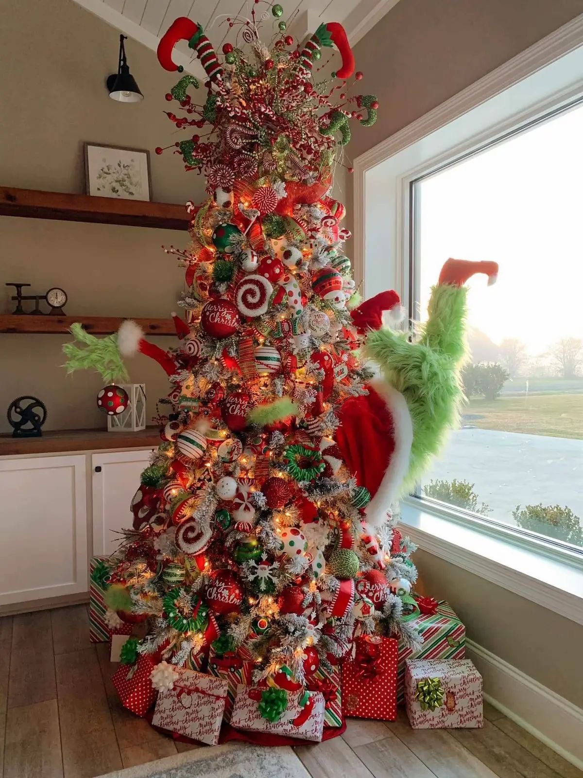 24 Fun Grinch Christmas Tree Ideas You'll Love 60 24 Fun Grinch Christmas Tree Ideas You'll Love Grinch Christmas tree with elf legs topper, candy cane sprays and red and green decorations