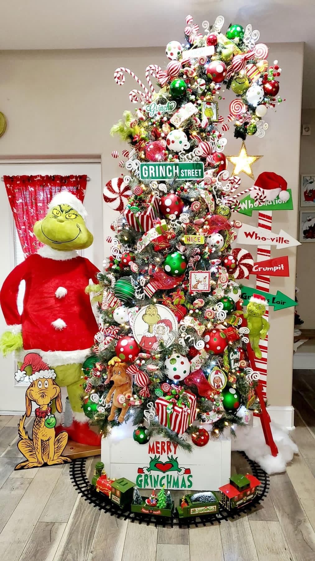 24 Fun Grinch Christmas Tree Ideas You'll Love 65 24 Fun Grinch Christmas Tree Ideas You'll Love Grinch Street Christmas tree with colourful candy ornaments, Grinch figures and a holiday train