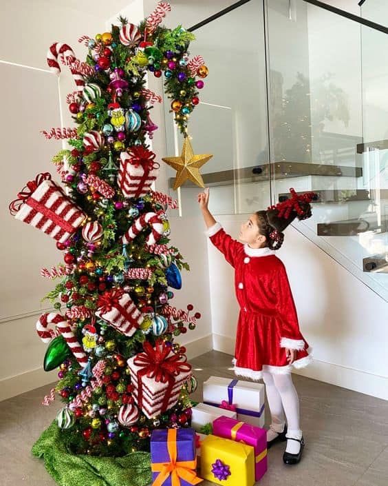 24 Fun Grinch Christmas Tree Ideas You'll Love 66 24 Fun Grinch Christmas Tree Ideas You'll Love Whimsical Grinch Christmas tree with striped presents, candy decorations and colourful gift boxes
