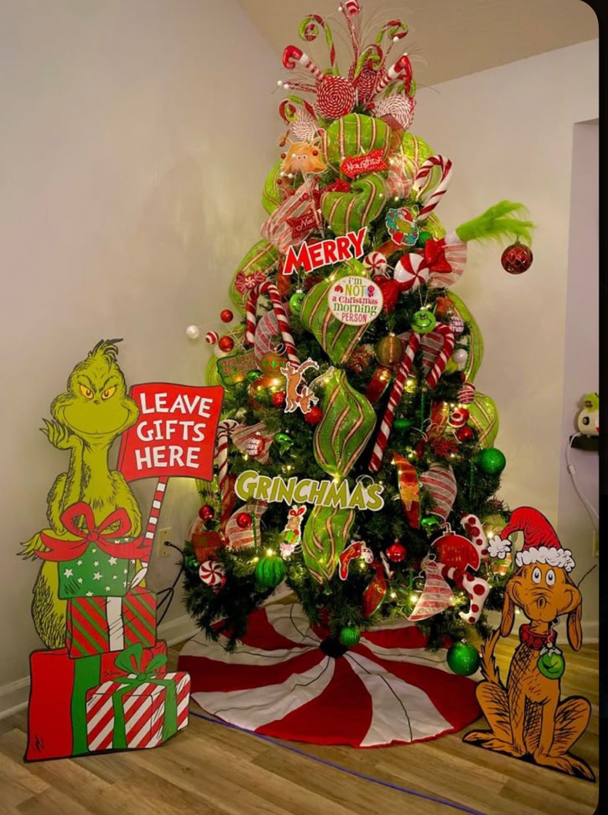 24 Fun Grinch Christmas Tree Ideas You'll Love 67 24 Fun Grinch Christmas Tree Ideas You'll Love Grinch Christmas tree with giant lime green ribbon loops, candy cane ornaments and festive character signs