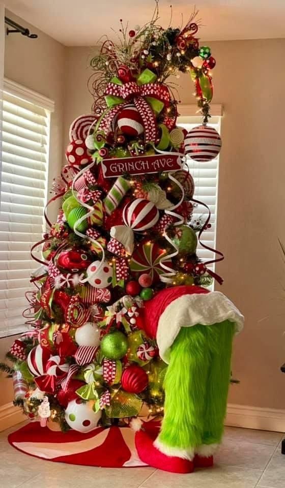 24 Fun Grinch Christmas Tree Ideas You'll Love 50 24 Fun Grinch Christmas Tree Ideas You'll Love Grinch Christmas tree with furry green legs, Santa boots and red and white candy ornaments