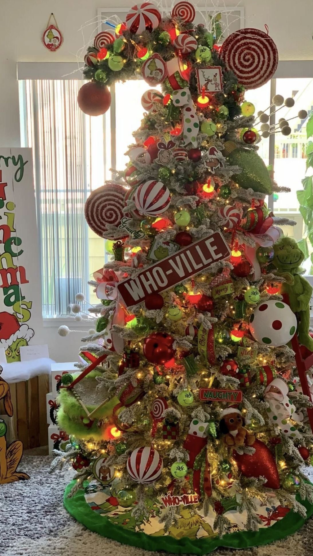24 Fun Grinch Christmas Tree Ideas You'll Love 68 24 Fun Grinch Christmas Tree Ideas You'll Love Snowy Grinch Christmas tree with oversized peppermint lollipops and a Who-Ville sign