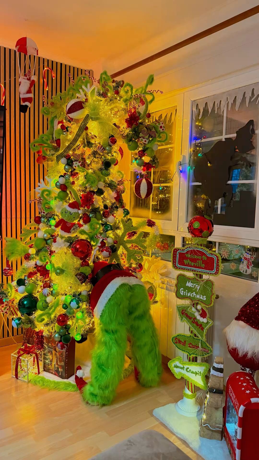 24 Fun Grinch Christmas Tree Ideas You'll Love 69 24 Fun Grinch Christmas Tree Ideas You'll Love Glowing Grinch Christmas tree with yellow lights, green furry legs and colourful decorations