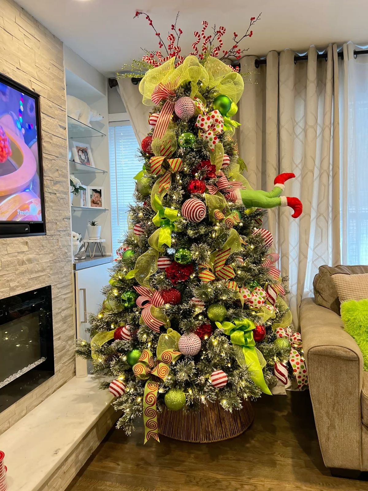 24 Fun Grinch Christmas Tree Ideas You'll Love 54 24 Fun Grinch Christmas Tree Ideas You'll Love Grinch Christmas tree with lime green mesh bows, striped ornaments and green Grinch legs